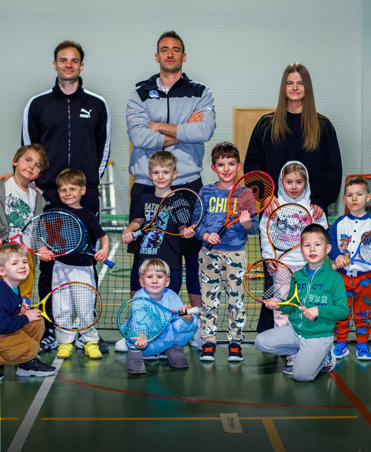 Grupa dzieci i trenerzy na zdjęciu pamiątkowym w hali Akademii Tenisowej RKT Return Radom